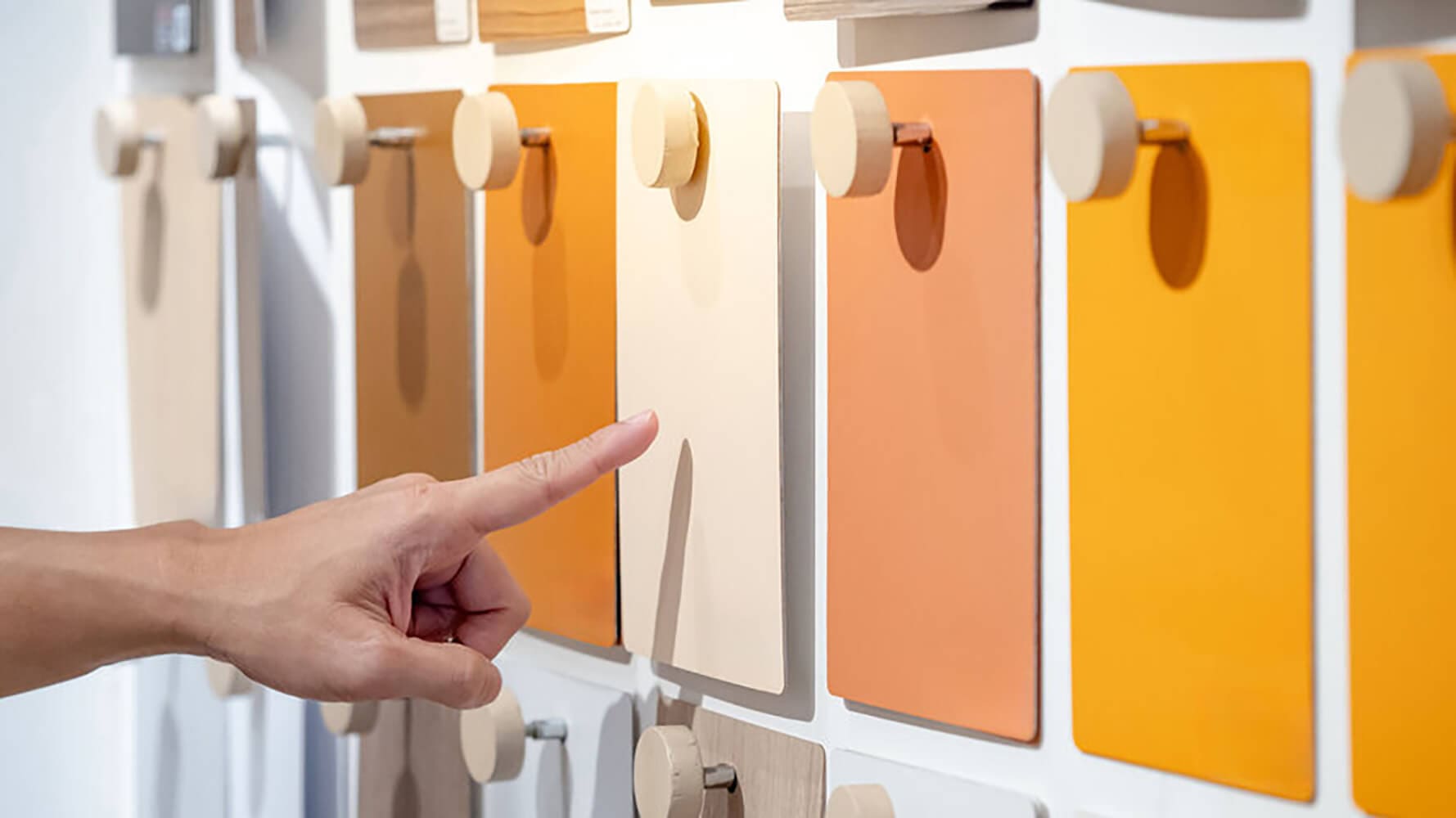 Homeowner selecting paint samples on a display while deciding how to choose the best interior paint finish for their walls