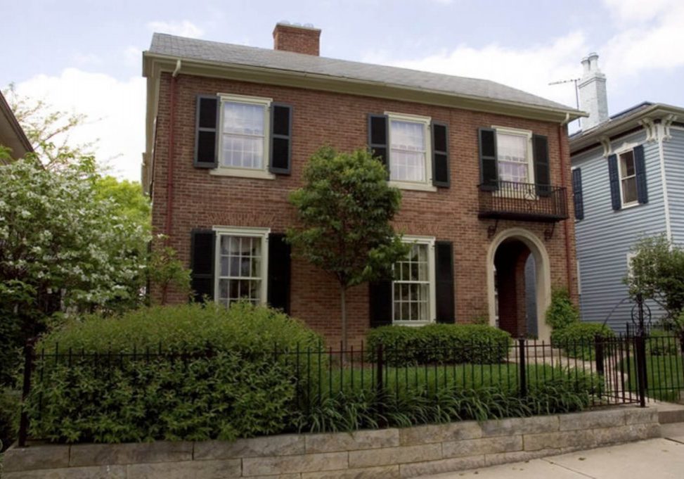 A traditional two-story brick home exterior, the type of surface homeowners weigh when comparing brick staining vs painting.