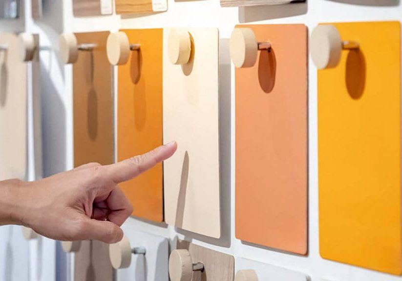 Homeowner selecting paint samples on a display while deciding how to choose the best interior paint finish for their walls